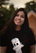 a woman with long dark hair wearing a t - shirt with a dog on it