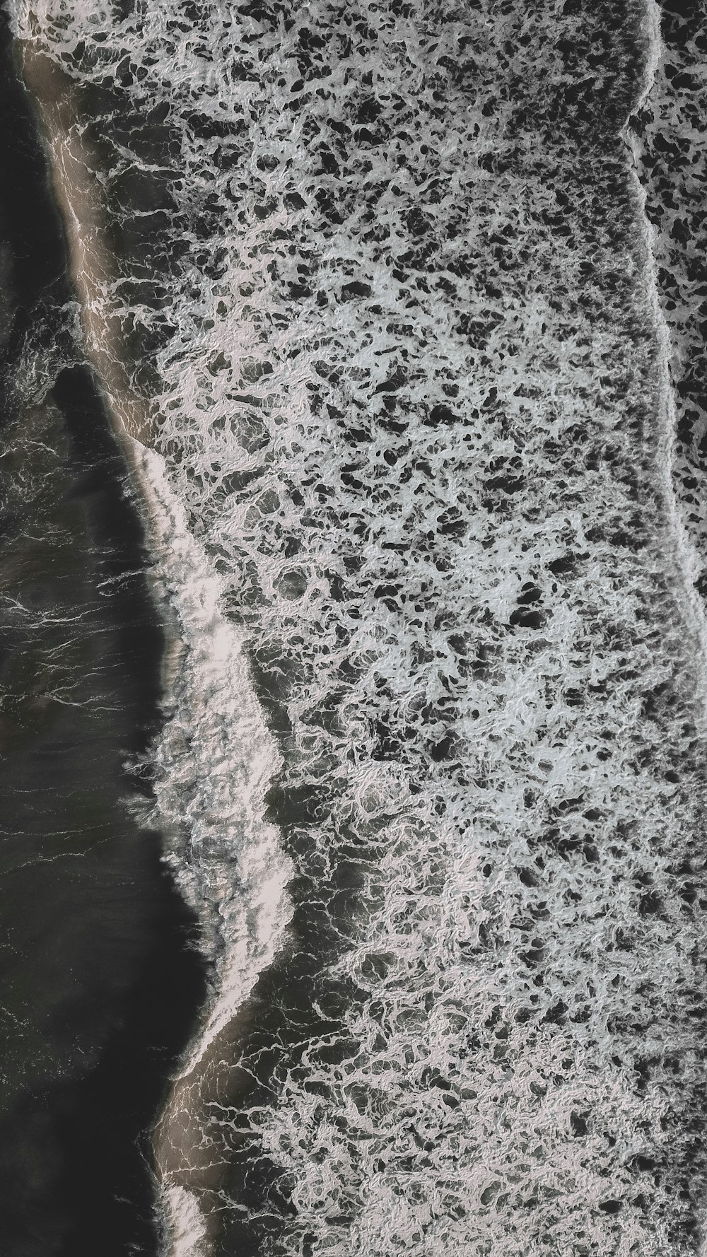 an aerial view of a beach with waves crashing on it