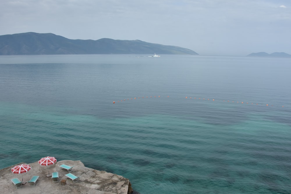 海の近くの崖の上に座っている椅子のカップル