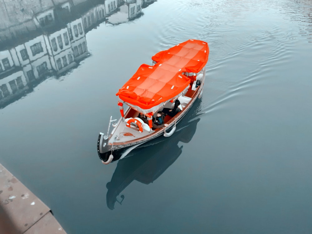 a boat with an orange cover is in the water