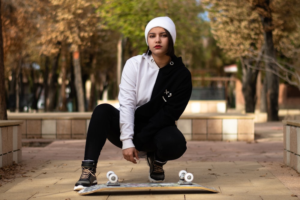 a woman squatting on a skateboard in a park