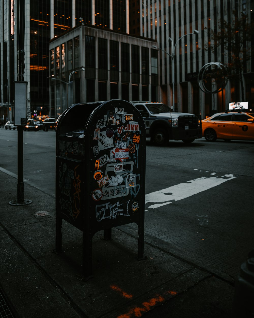 a mailbox covered in graffiti on a city street