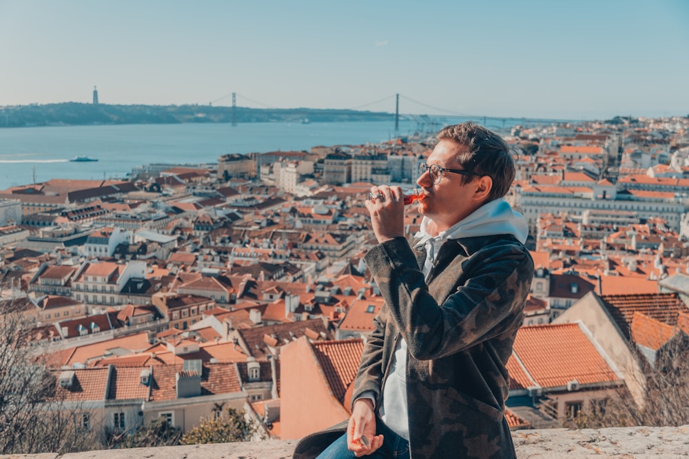 a man sitting on top of a stone wall