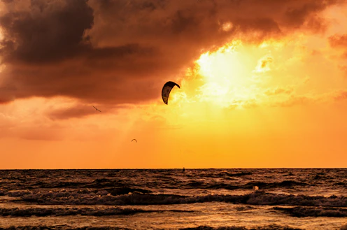 a person para sailing in the ocean at sunset