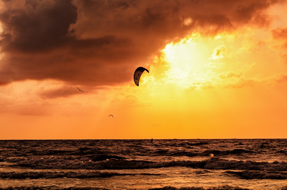 a person para sailing in the ocean at sunset