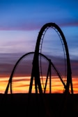 a roller coaster at sunset with the sky in the background