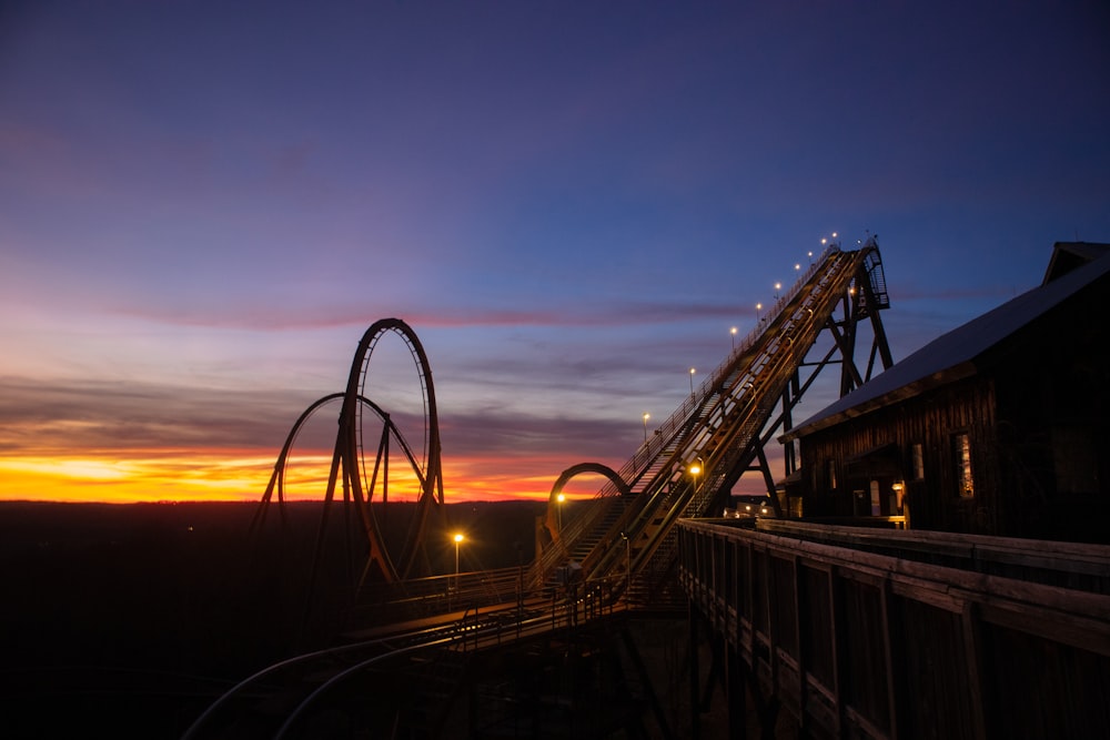 a roller coaster at sunset with the sky in the background
