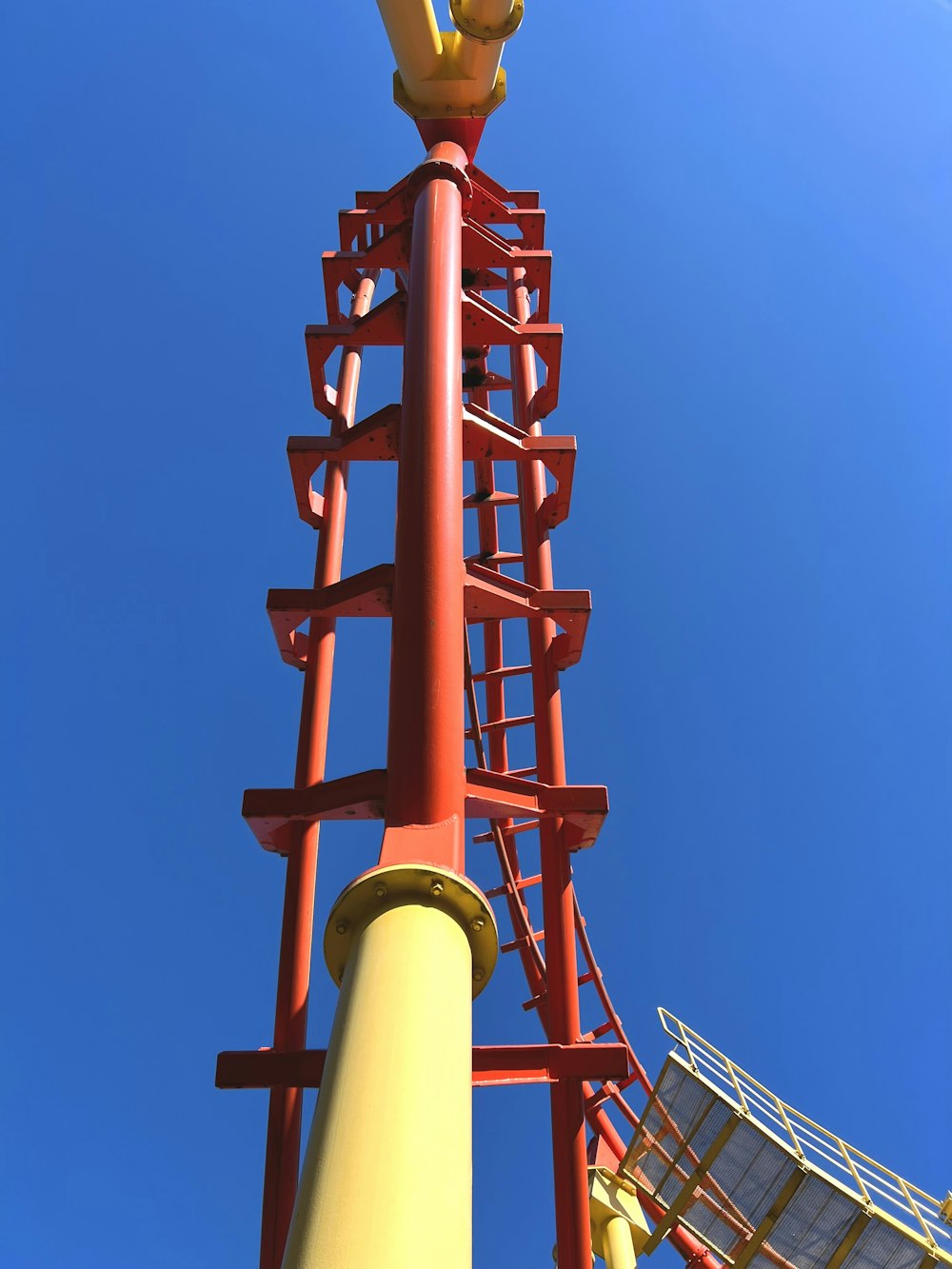 a tall red and yellow tower with a sky background