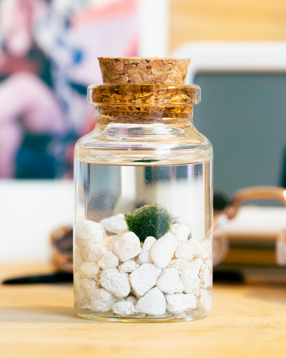 a glass jar filled with white and green rocks