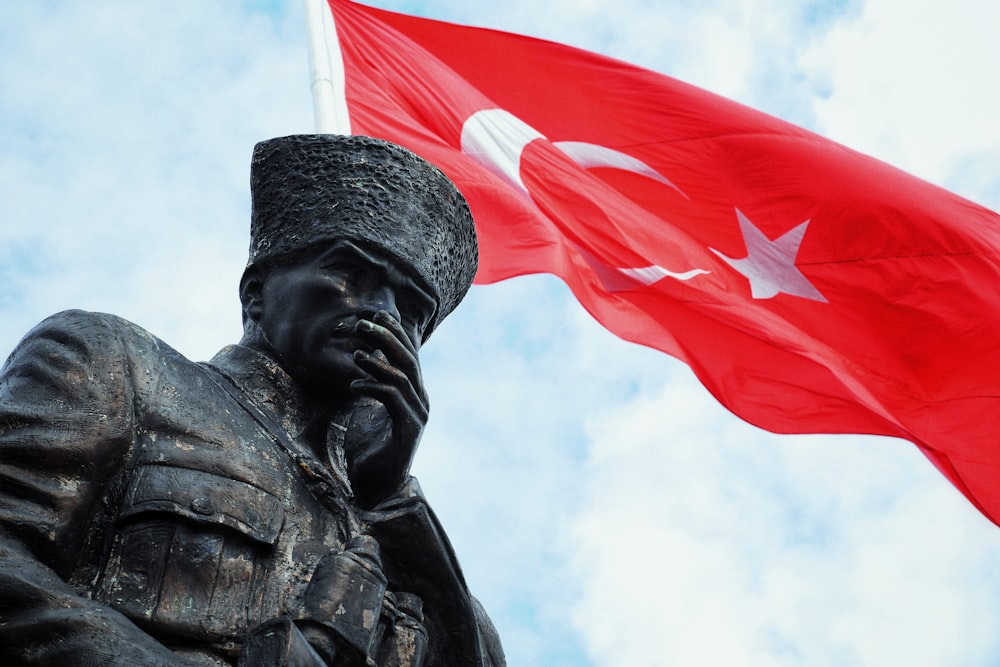 a statue of a man holding a red flag