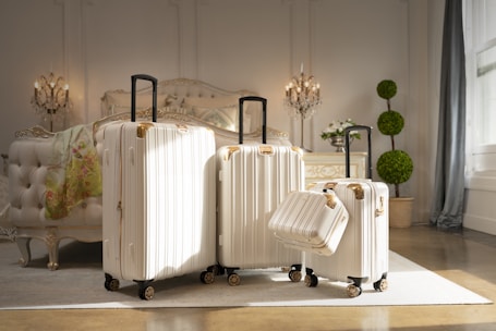 three pieces of white luggage sitting in a room