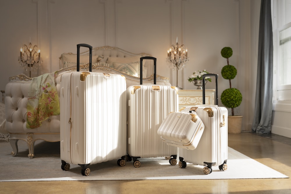 three pieces of white luggage sitting in a room