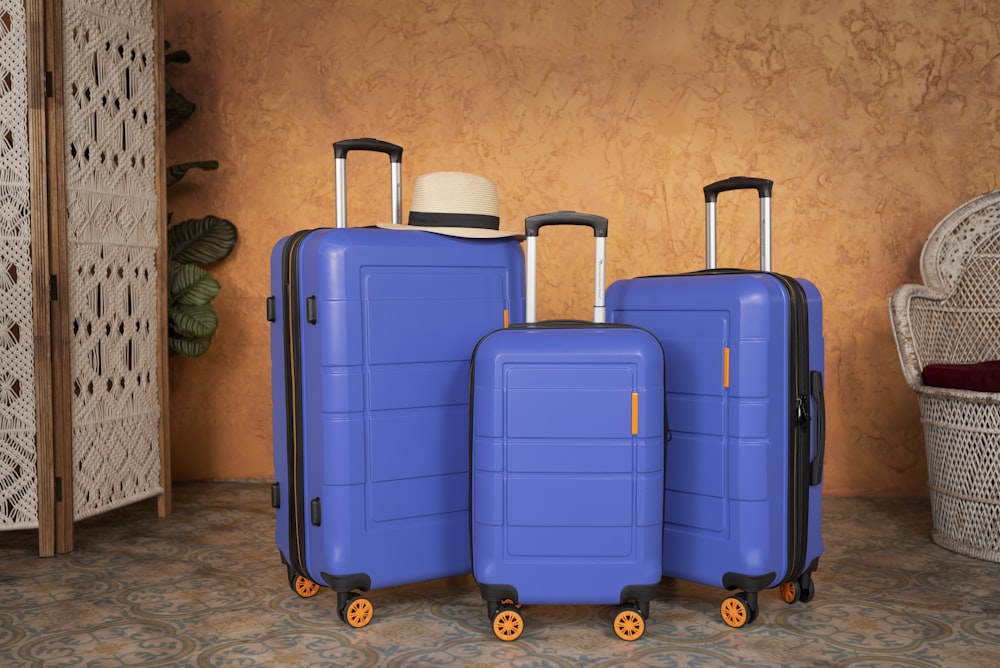 Tres piezas de equipaje azul sentadas una al lado de la otra