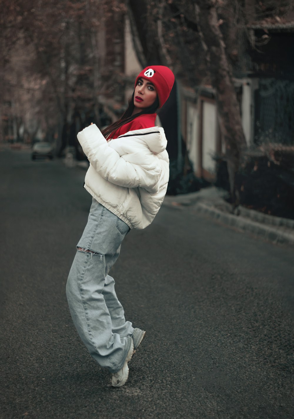 a woman in a white jacket and a red hat