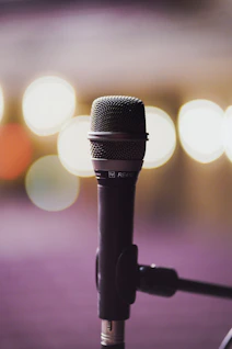 a close up of a microphone with blurry lights in the background