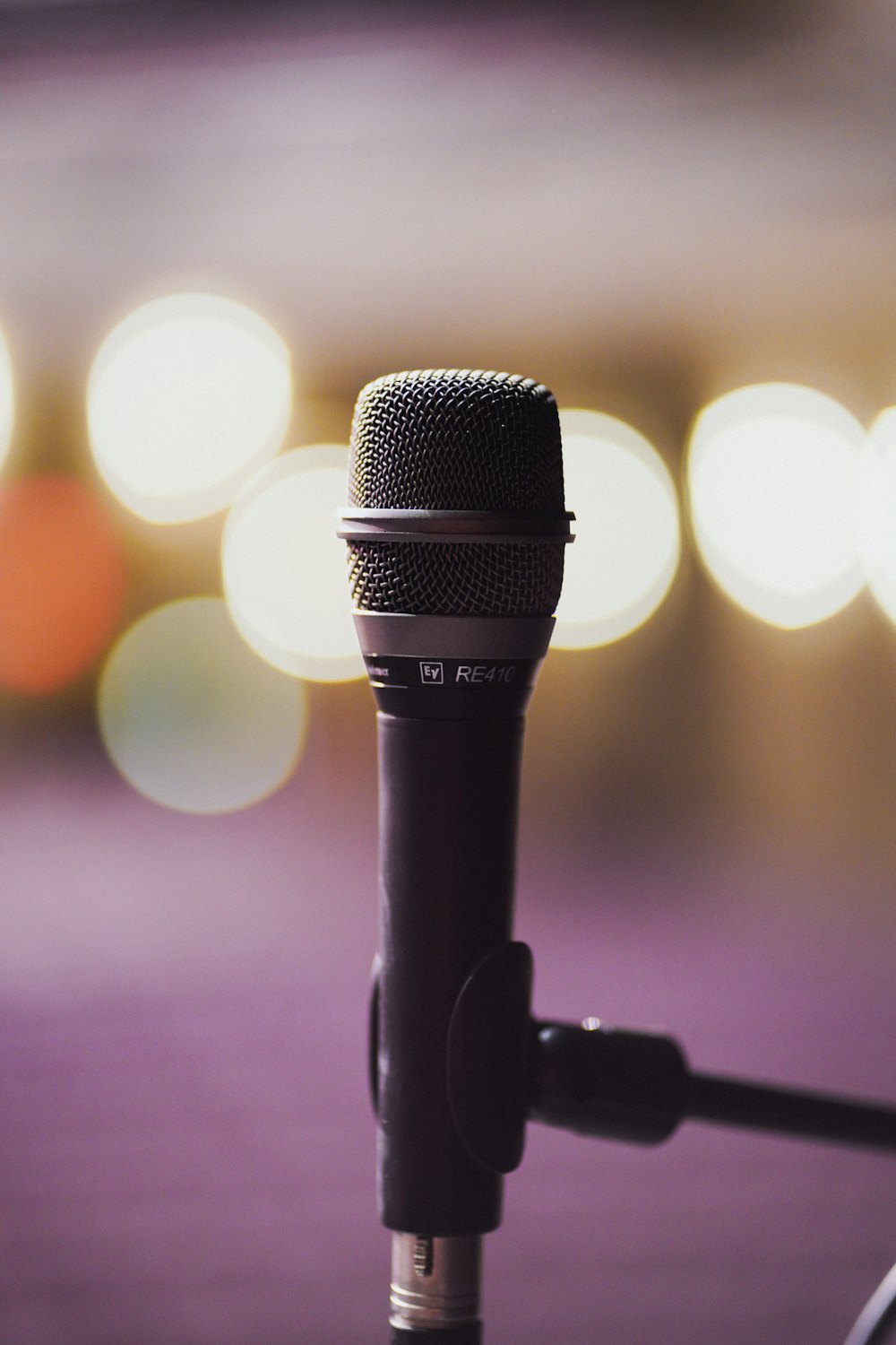 a close up of a microphone with blurry lights in the background