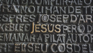 the word jesus written on a stone wall