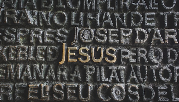 the word jesus written on a stone wall