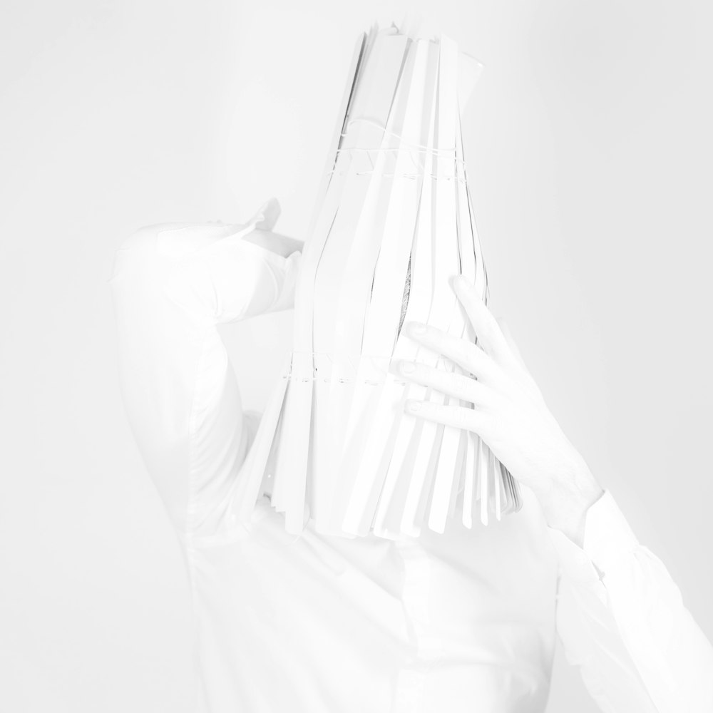 a woman in a white shirt is covering her face with her hands