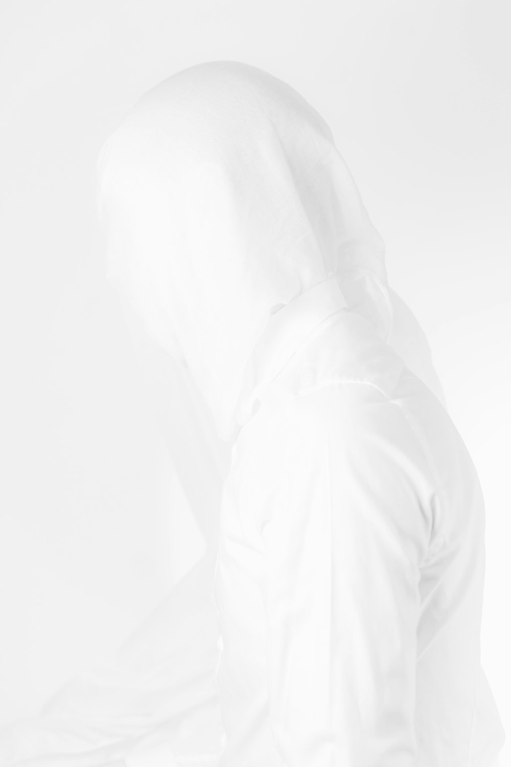 a person in a white jacket with a hood up