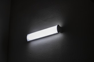 Close-up of a wallwasher LED light installed highlighting a textured wall.