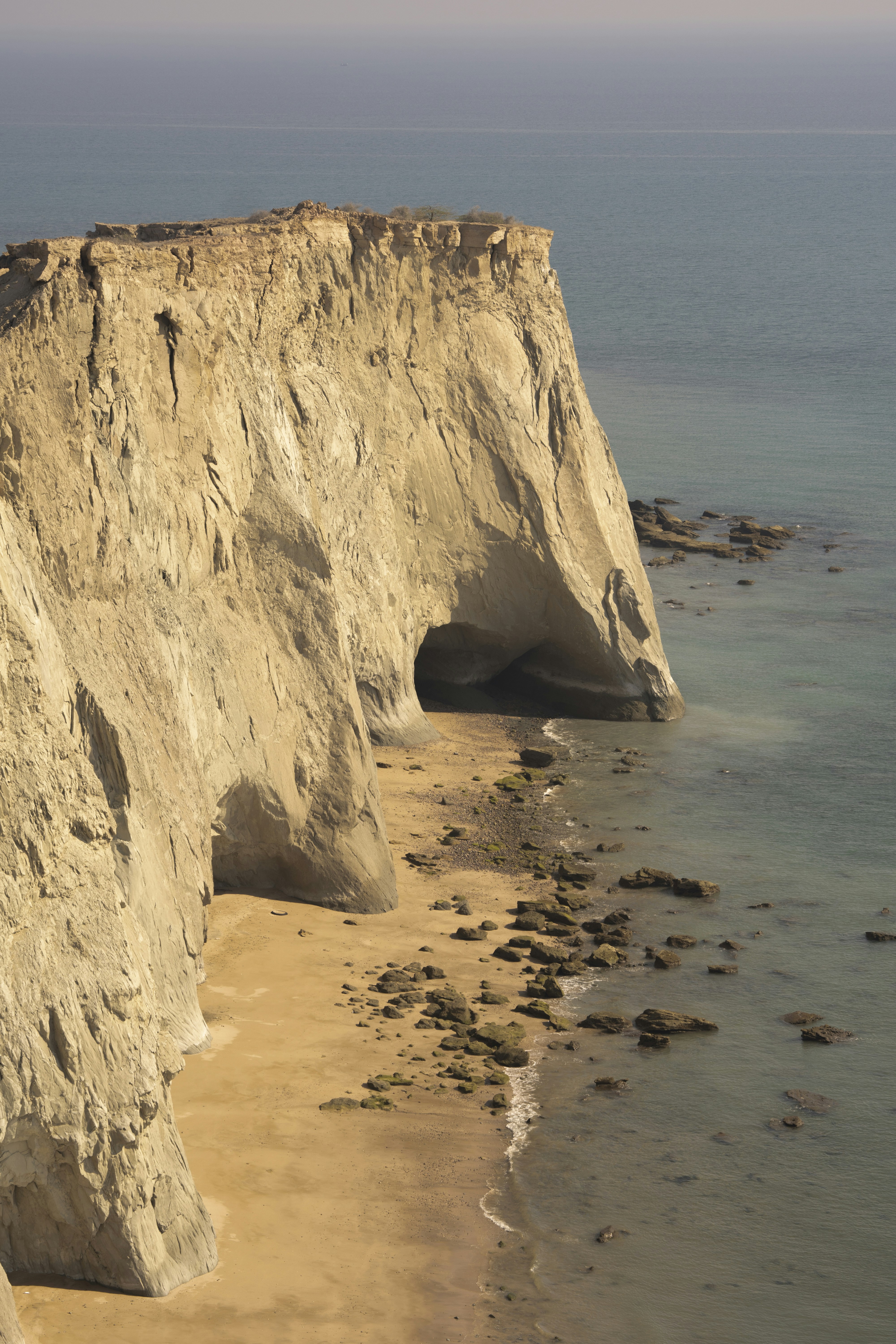 a beach with a cliff and a body of water
