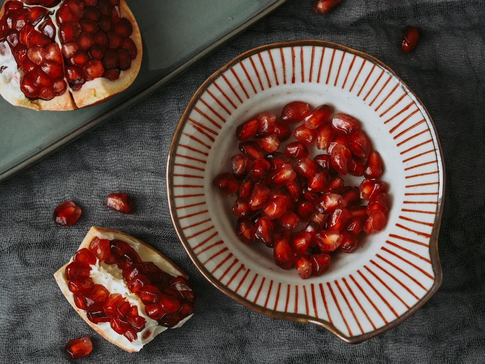 a bowl of pomegranate sitting on top of a table