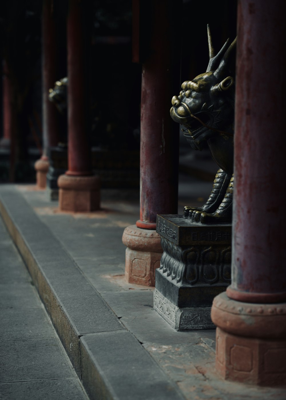 a statue of a dragon in a row of pillars