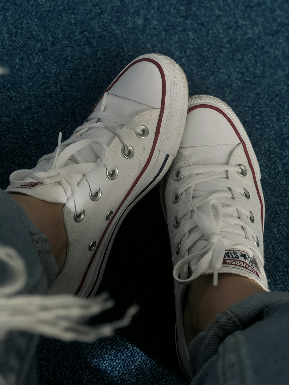 a pair of white shoes sitting on top of a blue couch