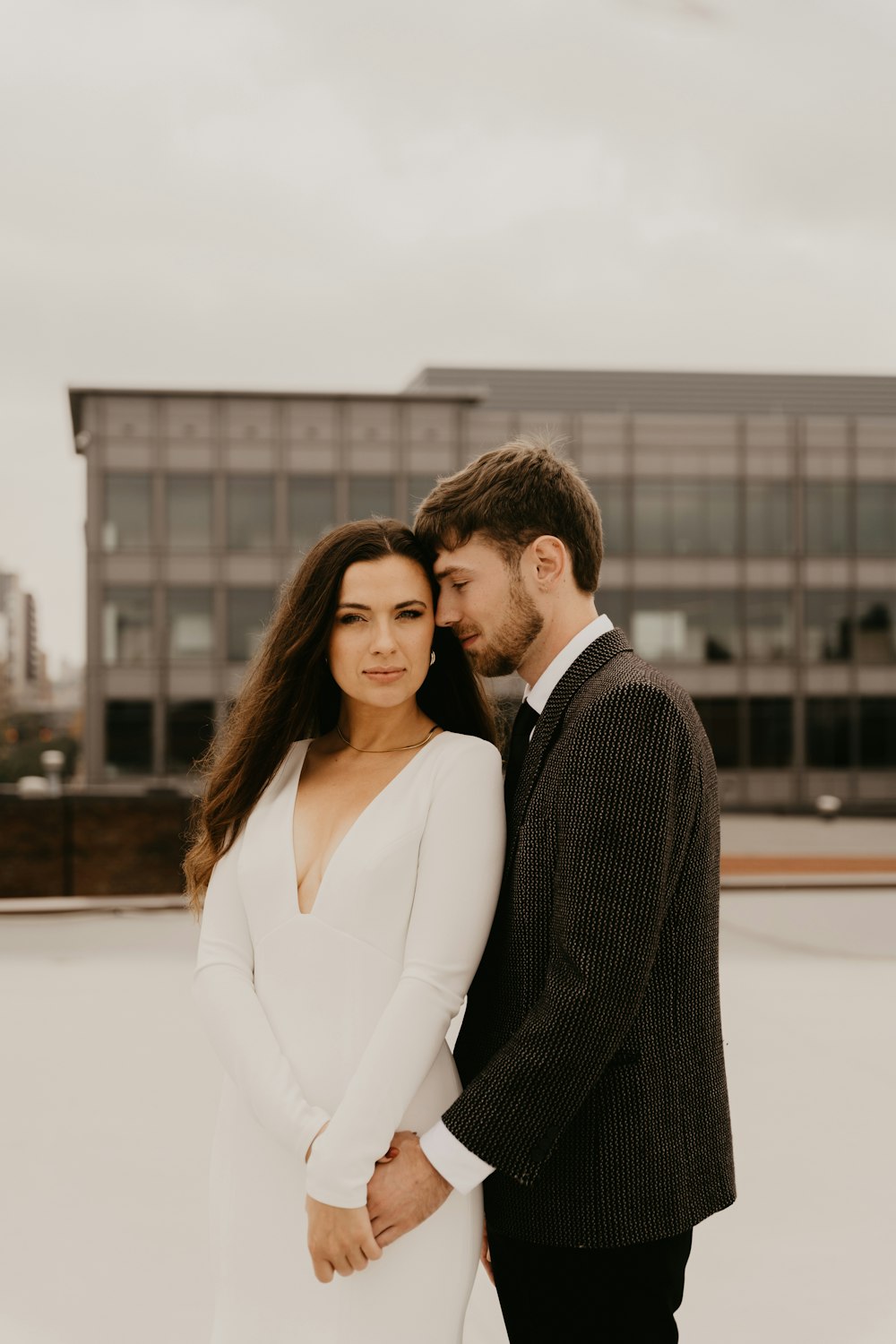 a man and woman standing next to each other in front of a building