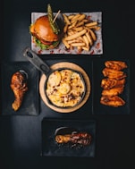 a table topped with plates of food and a burger