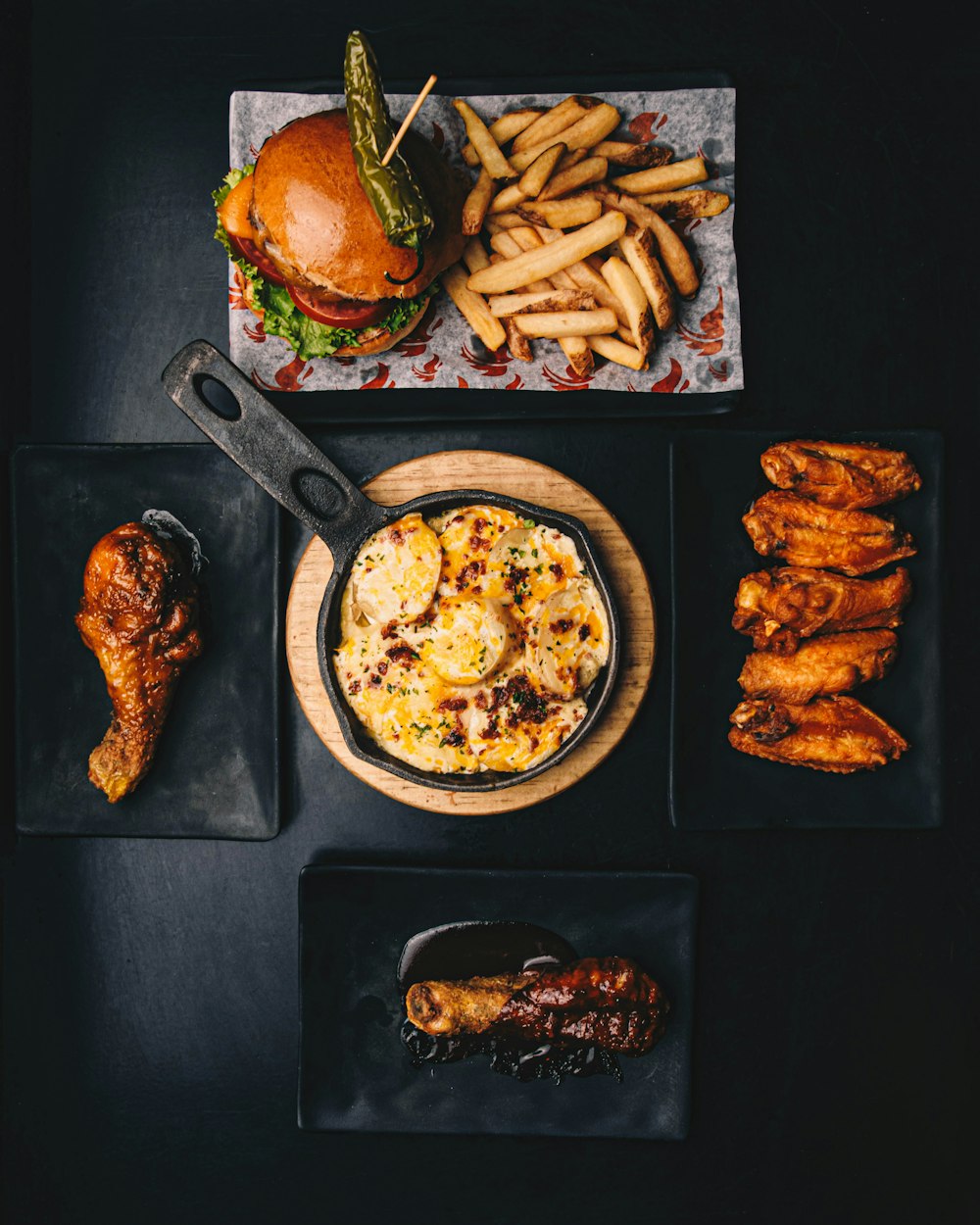 a table topped with plates of food and a burger