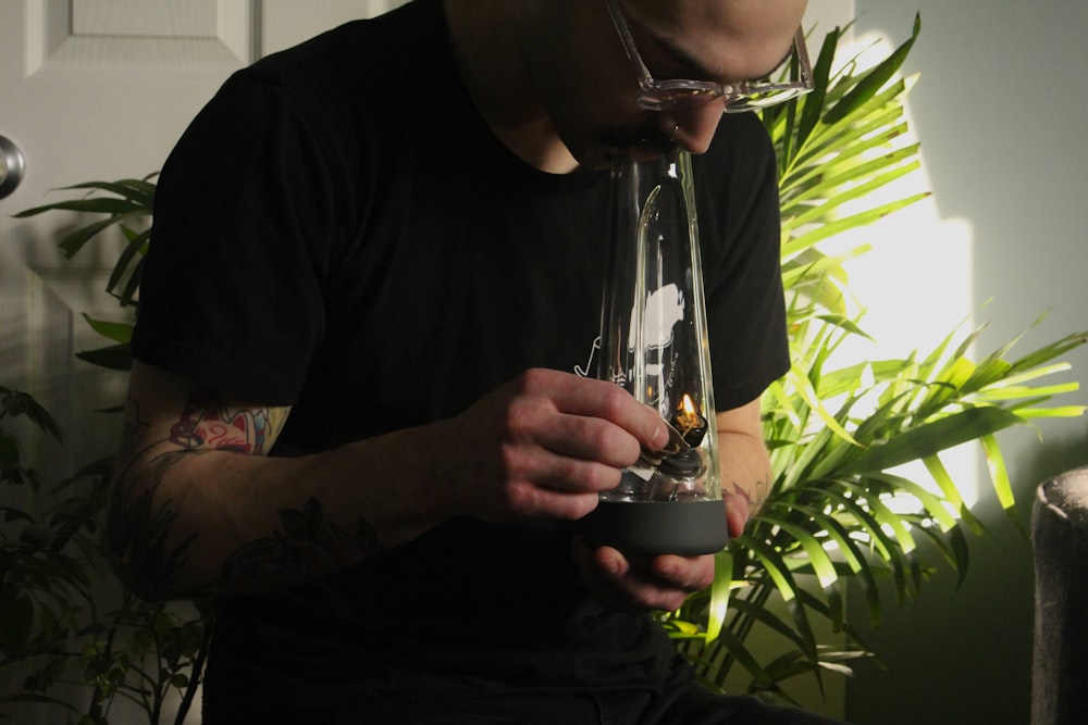 a man with a tattoo on his arm holding a glass