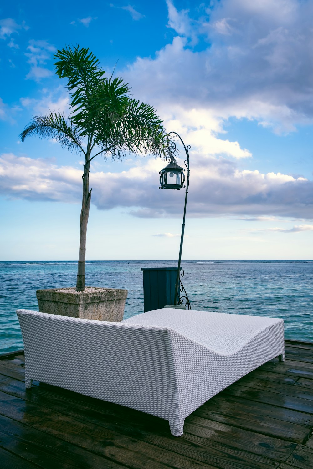 a white couch sitting on top of a wooden dock