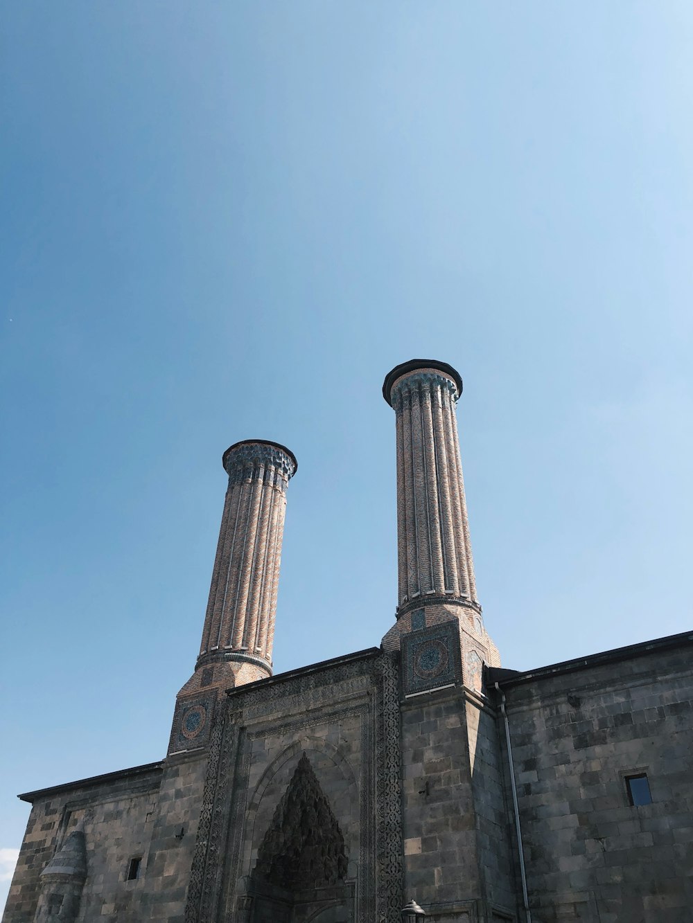 two stone pillars stand in front of a building