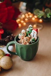 a cup filled with christmas cookies on top of a table