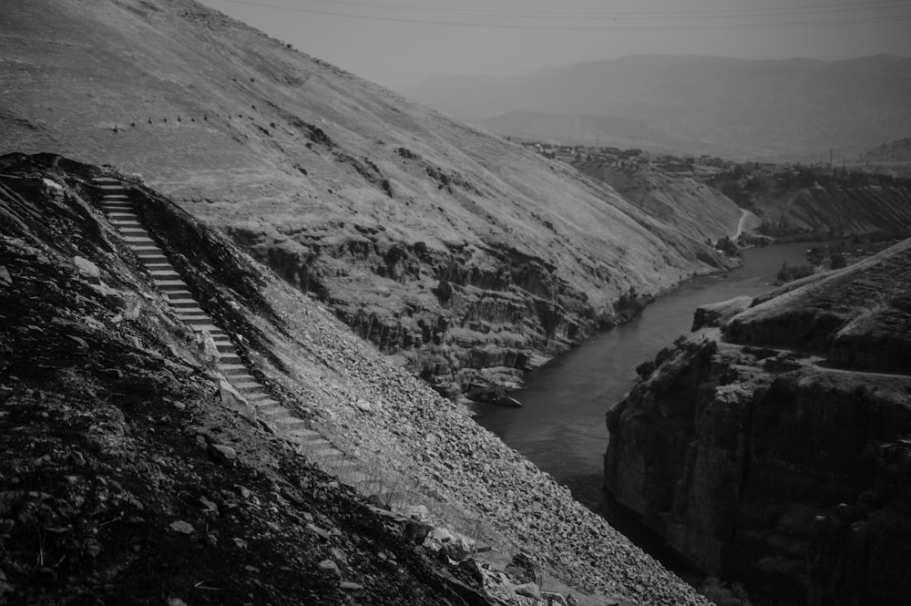 a black and white photo of a train going down the tracks