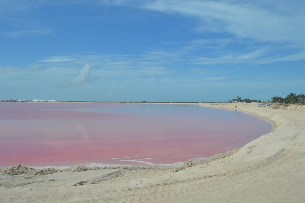 a large body of water sitting on top of a sandy beach