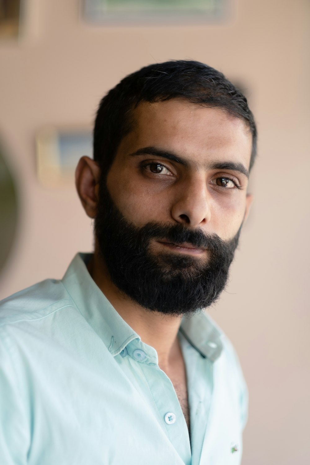 Un uomo con la barba che indossa una camicia blu