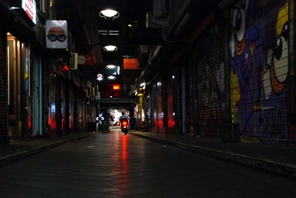 une personne marchant dans une ruelle sombre