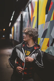 a man standing in front of a colorful wall