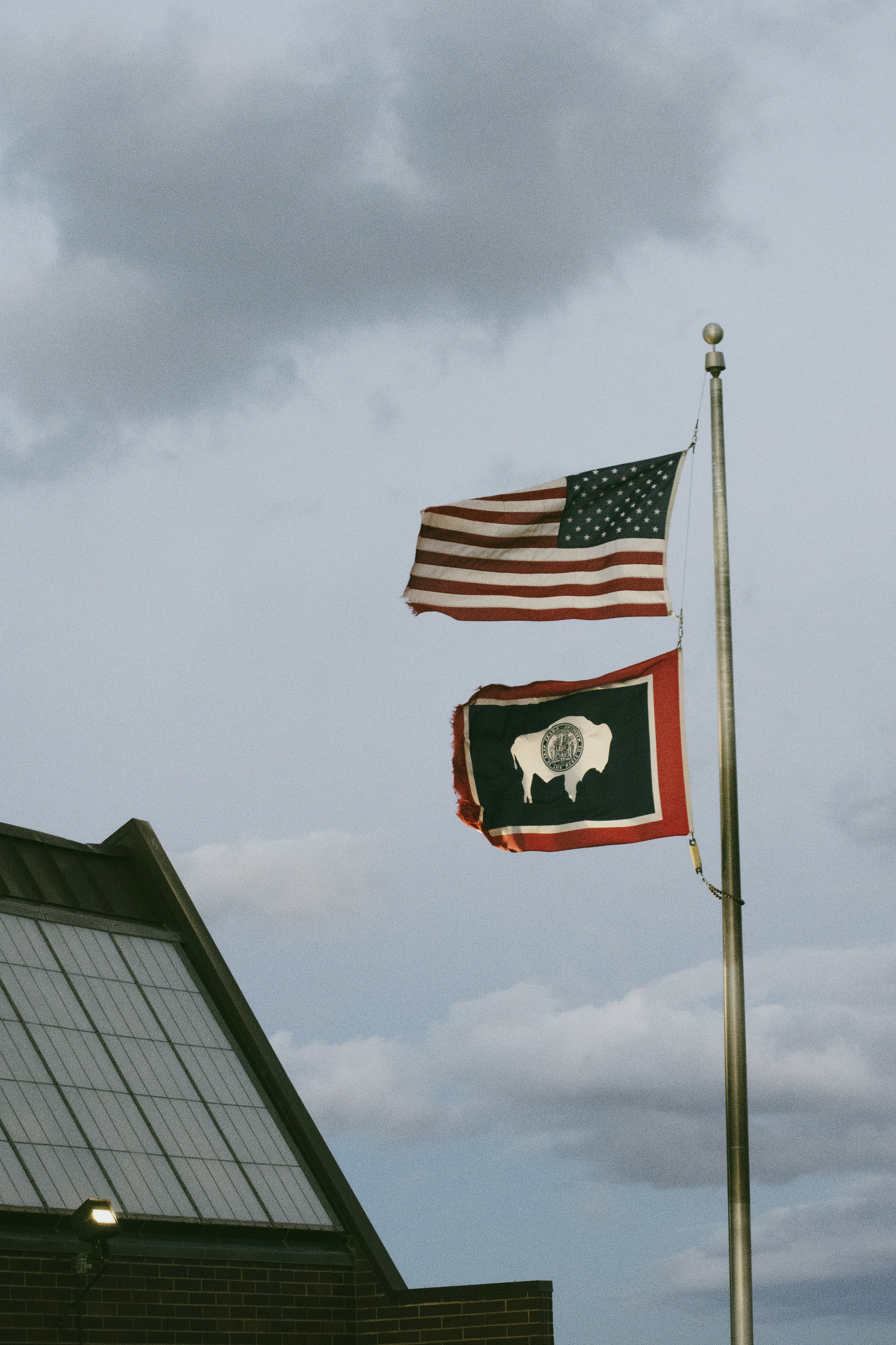 two flags flying next to each other on a pole