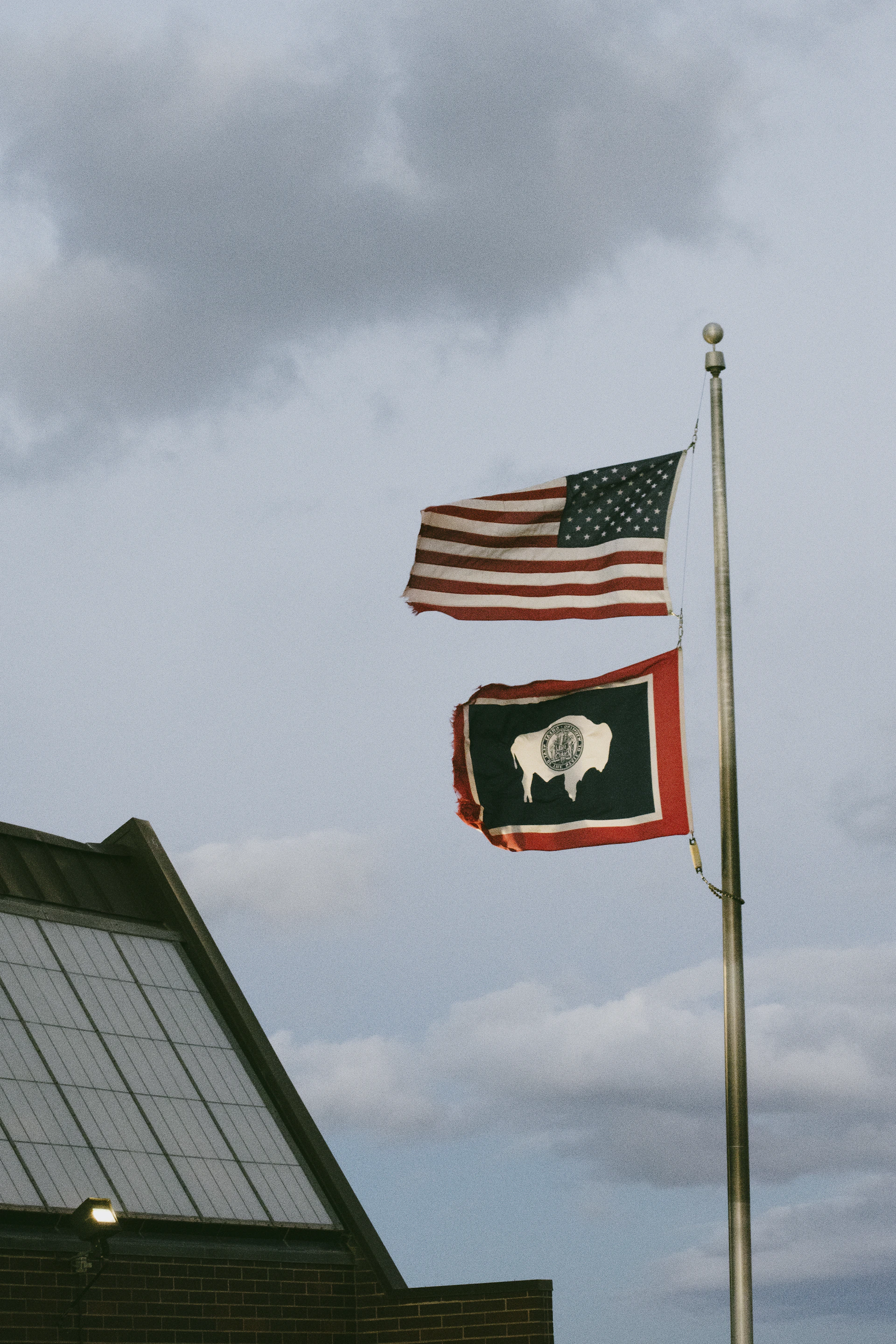 two flags flying next to each other on a pole