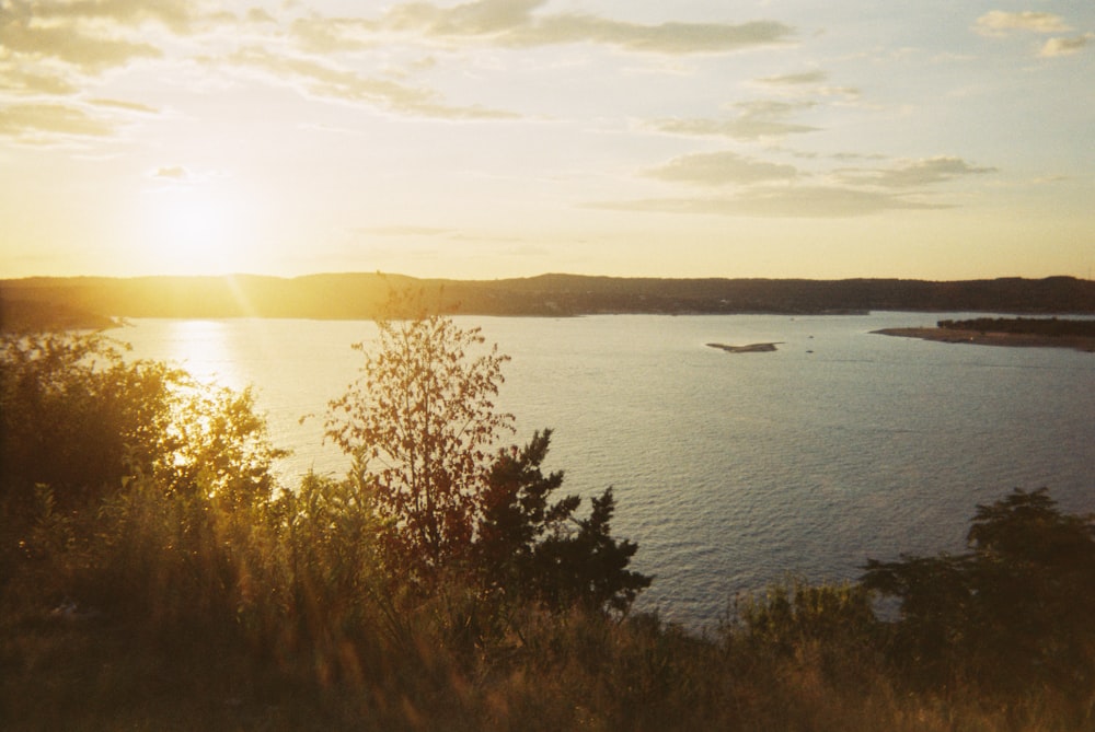 the sun is setting over a large body of water