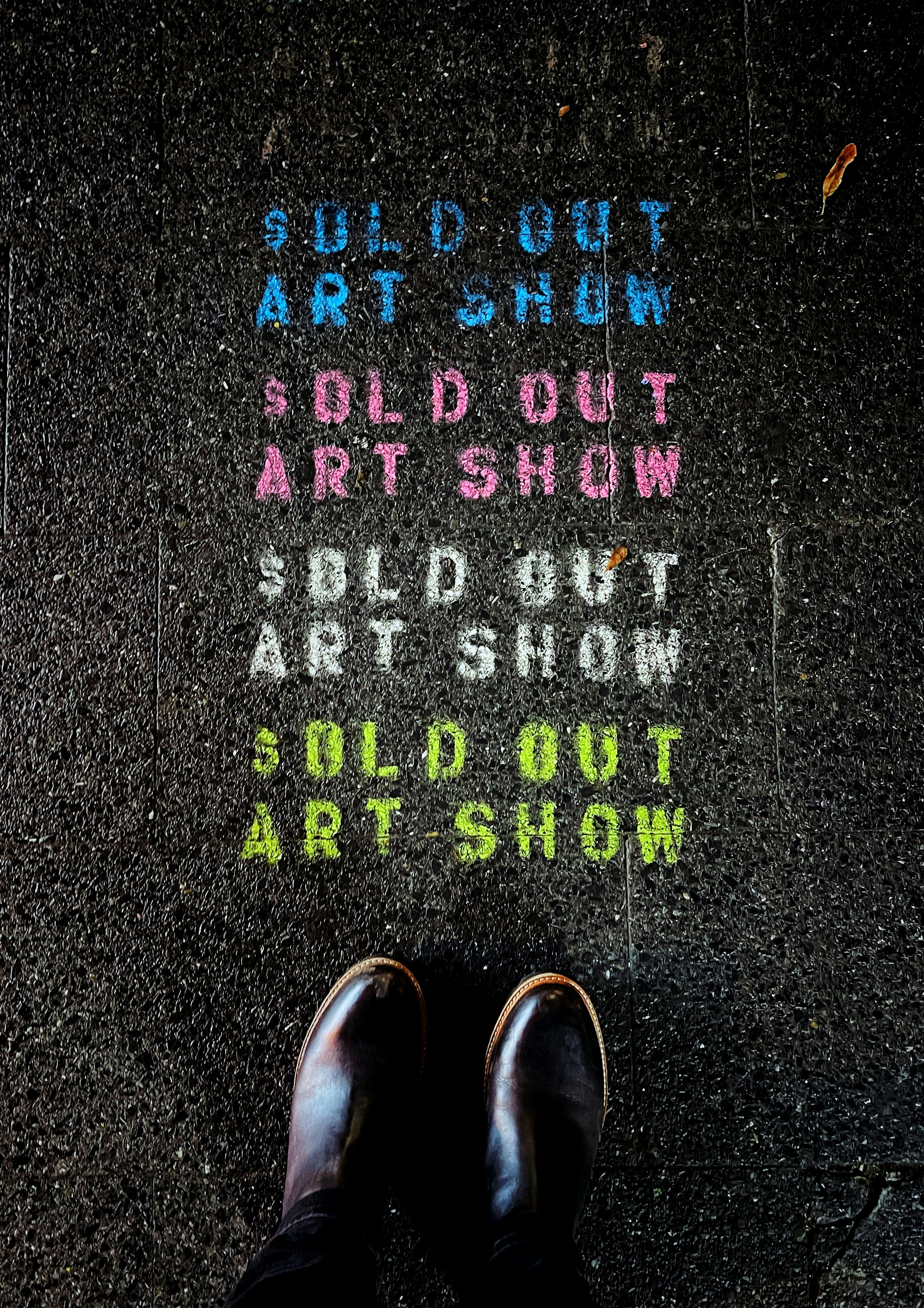 a person standing in front of a sidewalk with chalk writing on it