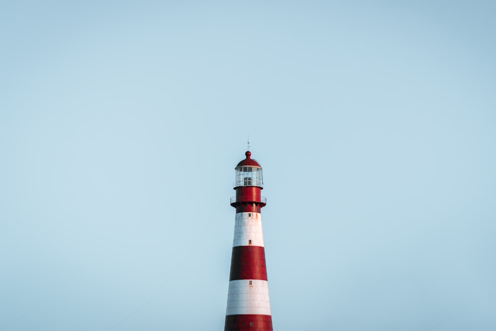 a red and white lighthouse on a clear day