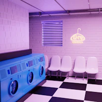 A bright and clean laundry shop interior with washing machines and folded clothes.