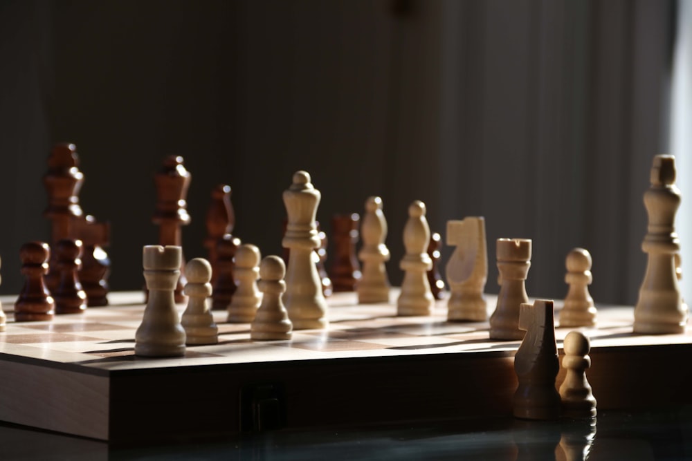 a wooden chess board with pieces on it