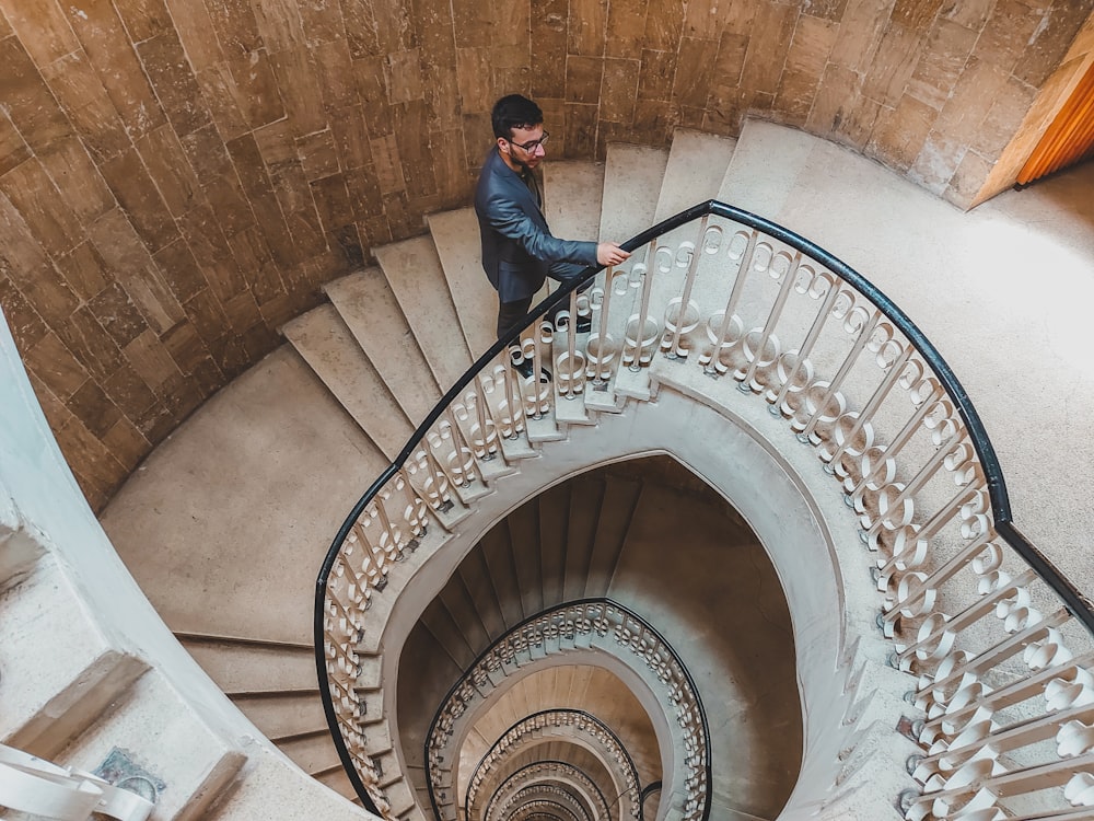 a man standing on the top of a spiral staircase