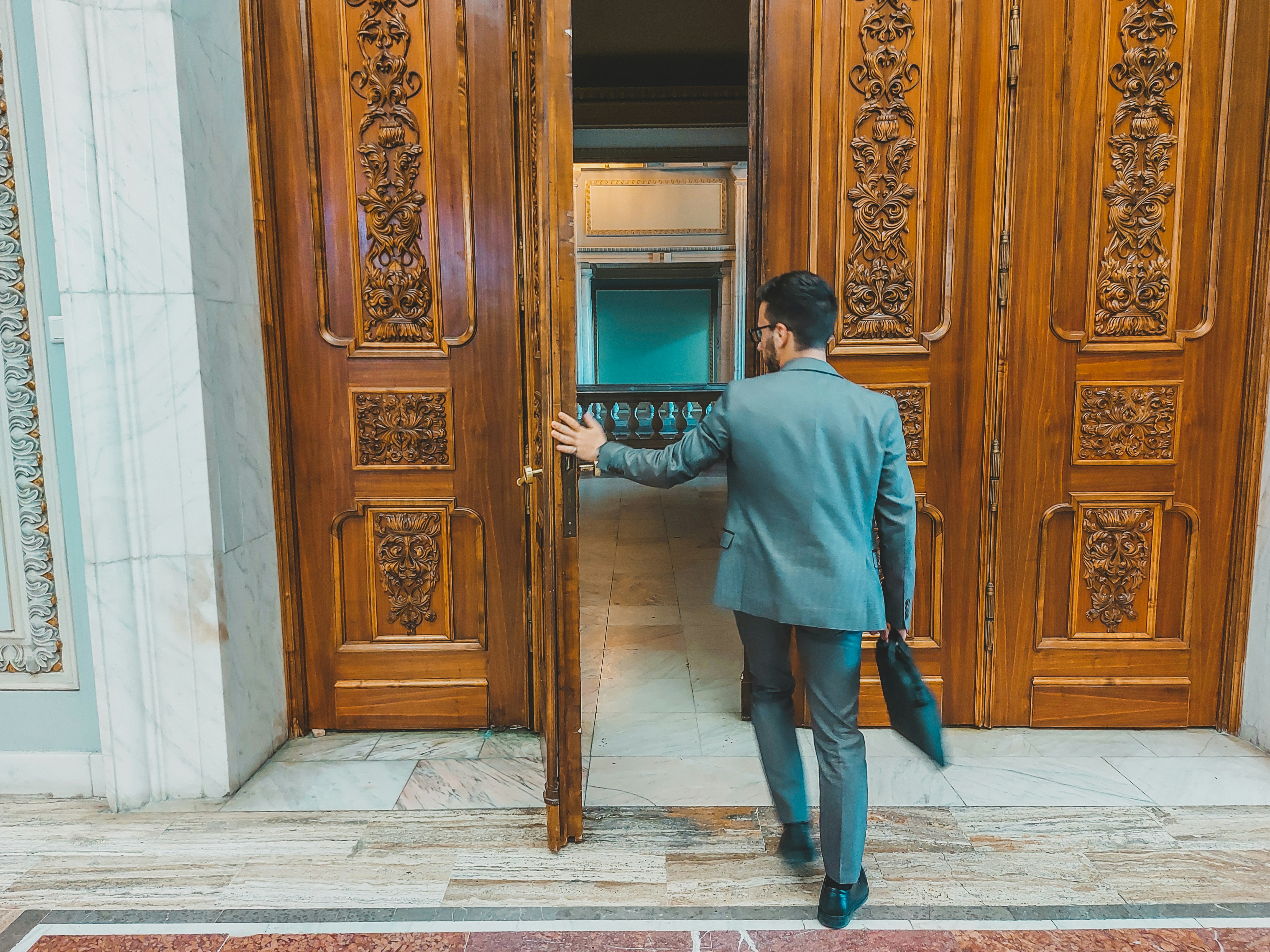a man in a suit is entering a building